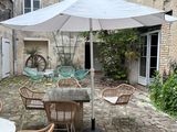 a table with chairs and an umbrella in a courtyard