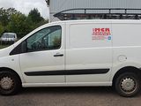a white van parked in front of a building