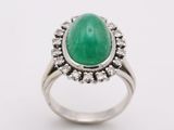 a close up of a ring with a green stone surrounded by diamonds