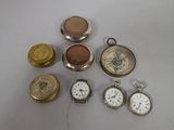 many different types of pocket watches sitting on a table