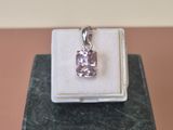 une photo d'un pendentif en diamant rose posé sur un coffret blanc