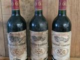 three bottles of wine sitting on a shelf next to each other