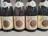 six bottles of wine are lined up in a row on a table