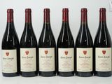 six bouteilles de vin rouge sont alignées sur une table