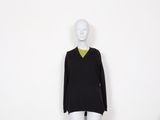 a mannequin wearing a black sweater with a yellow collar