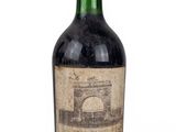 une vieille bouteille de vin posée sur une surface blanche