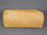 an image of a tan leather purse on a grey background