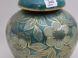 a vase with a lid that has a flower design on it