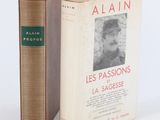 un vieux livre posé à côté d'un livre encore plus ancien sur une surface blanche