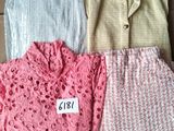 trois paires de pulls sont posées sur une boîte en carton sur laquelle est accrochée une étiquette de prix