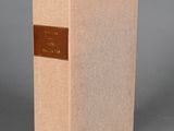 an old book sitting on top of a table next to a gray wall