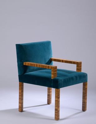an upholstered chair with a wooden frame and blue velvet upholstered seat