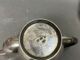 a silver tea pot sitting on top of a table