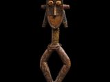 une sculpture en bois représentant un homme coiffé d'un chapeau