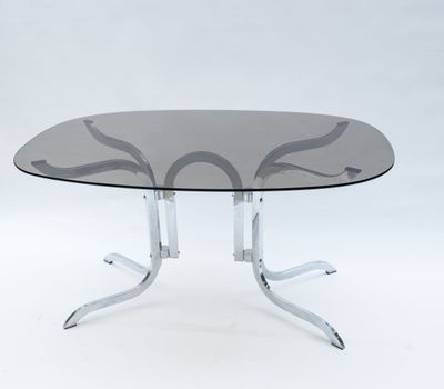 une table ronde en verre avec des pieds chromés et un plateau en verre