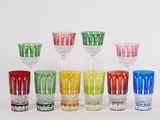 plusieurs verres de différentes couleurs empilés les uns sur les autres sur une surface blanche