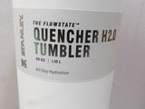a white cup with a sticker on it sitting on a table