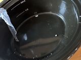 a black slow cooker sitting on a wooden table