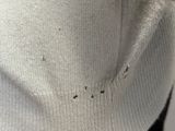the sweater is white with black spots on it