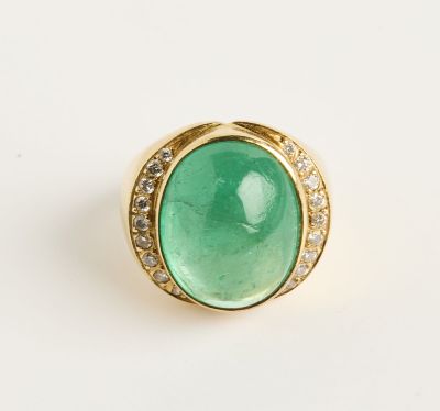 une bague en or sertie d'une pierre verte entourée de diamants
