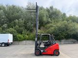 a red forklift truck parked in a parking lot
