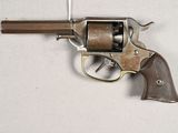 a small revolver with a wooden handle on a white surface