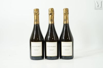 trois bouteilles de vin posées sur une table l'une à côté de l'autre