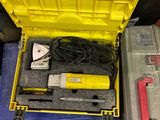 une boîte jaune contenant des outils, posée par terre