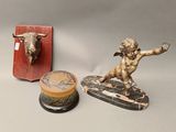 a statue of a man on a surfboard next to a box with a bull head on it