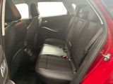 the back seats of a red car with a black seat belt
