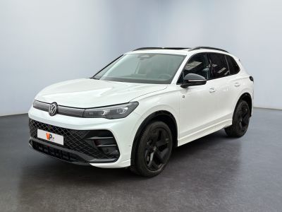 un SUV Volkswagen blanc garé dans une pièce au sol noir