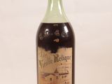 an old bottle of wine sitting on top of a white table
