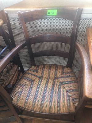 une chaise en bois avec une assise tressée et un panier sur le dossier