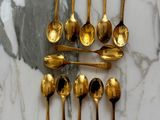 a lot of gold spoons and spoon spoons on a marble table