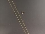a gold necklace with a white tag on it
