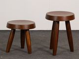 two wooden stools sitting next to each other on a carpeted floor