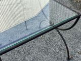 a glass table with a metal frame and a glass top