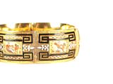 gros plan d'un bracelet en or sur fond blanc