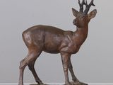 sculpture en bronze représentant un cerf aux bois, debout sur un rocher