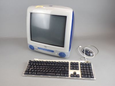 un petit ordinateur posé sur une table, équipé d'un clavier et d'une souris