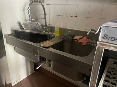 une cuisine équipée d'un évier et d'un lave-vaisselle