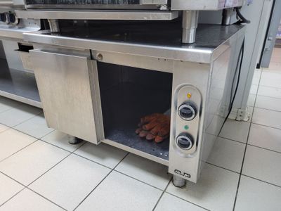 deux hot-dogs qui cuisent dans le four posé sur le plan de travail