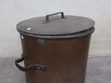 a large metal pot with a lid sitting on the floor
