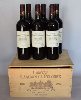 six bouteilles de vin rouge dans un coffret en bois sur une table