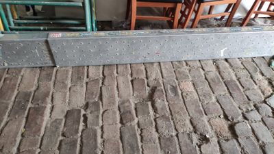 a metal rail that is sitting on a brick floor