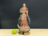 a statue of a man holding a green apple next to a statue of a woman