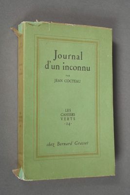 an old book sitting on top of a table with a green cover