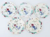 four plates with flowers and birds on them on a white surface