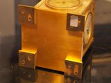 a gold clock sitting on top of a black table