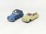 two toy cars sitting side by side on a white surface